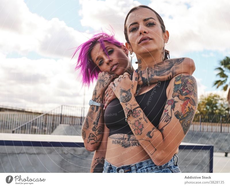 Informal women hugging in city pink hair informal friend millennial hipster together tattoo appearance urban street eccentric friendship bonding weekend town