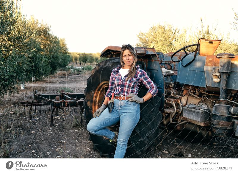 Female farmer with tractor on olive plantation harvest machine woman agriculture rural female satisfied adult small business owner work organic job agronomy