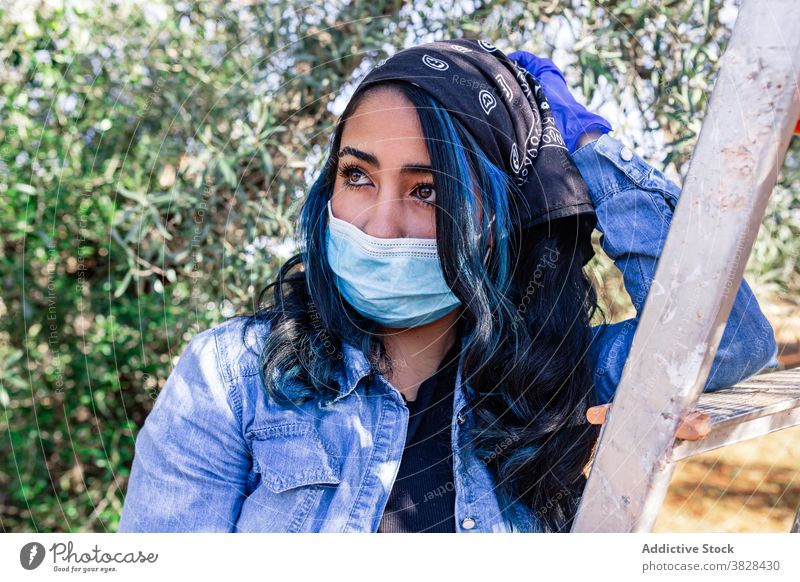 Young thoughtful female having break in harvesting woman mask tired orchard farm coronavirus plantation rest garden covid19 work ladder farmer cultivate