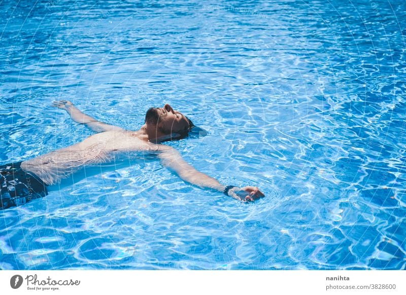 Young man enyoing the day at the swimming pool playful summer water attractive cool fresh holidays fun funny sport sportive swim trunks life lifestyle enjoy