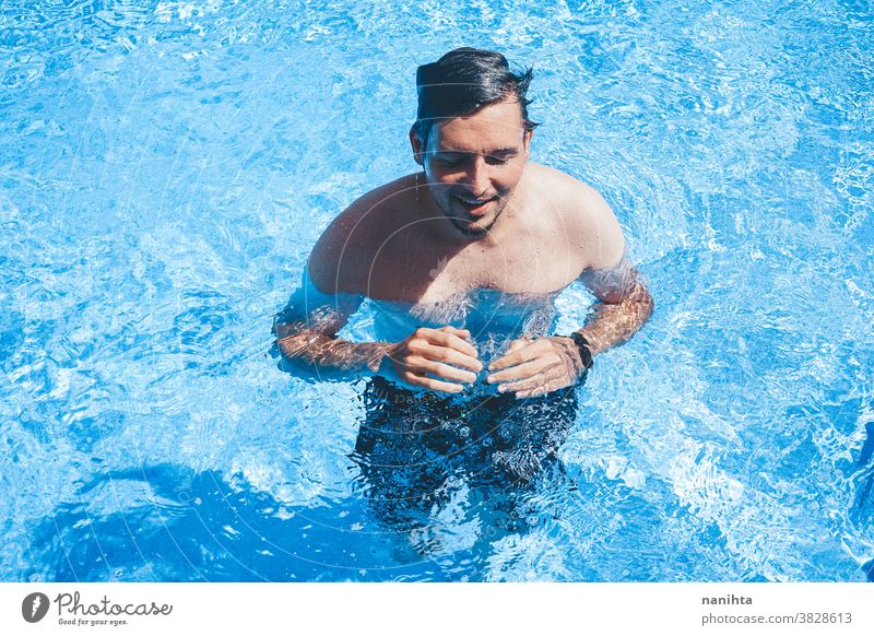 Young man enyoing the day at the swimming pool playful summer water attractive cool fresh holidays fun funny sport sportive swim trunks life lifestyle enjoy