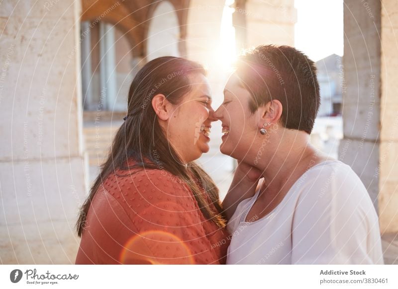 Lesbian couple kissing on street in sunshine lesbian love relationship eyes closed pleasure gentle women moment harmony idyllic amorous tender in love earring