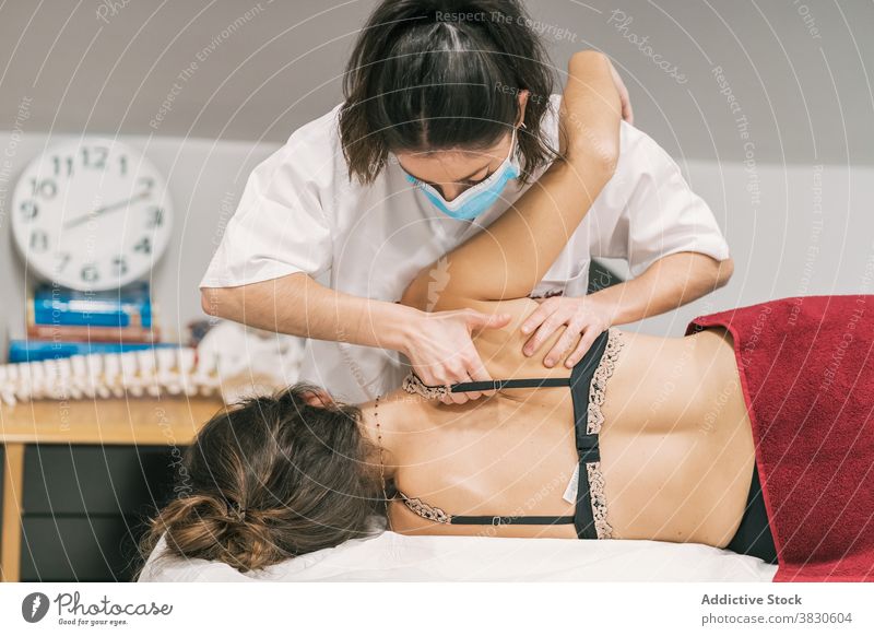 Masseuse doing therapeutic massage for patient rehabilitation back therapist therapy treat scapula clinic medicine professional care recovery help job visit