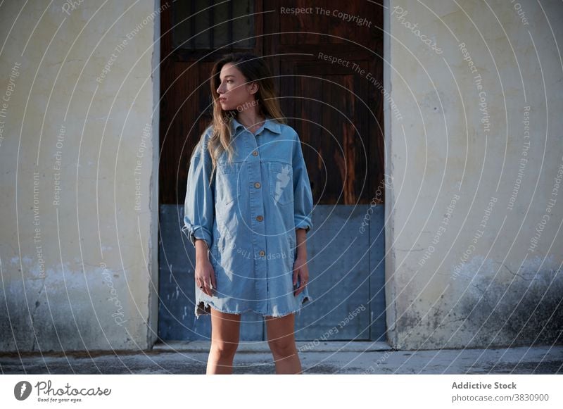 Stylish young woman standing near shabby building style denim dress countryside autumn trendy cold house slim female hoarfrost weathered rural season snow