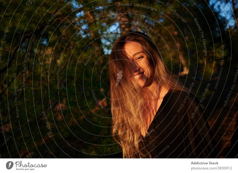 Young woman standing in autumn forest woods nature long hair sunlight season woodland cold female meadow snow sunny fall young environment travel hike adventure