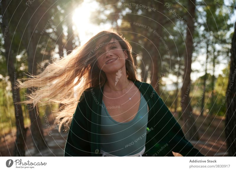 Young woman standing in autumn forest woods nature long hair sunlight season woodland cold female meadow snow sunny fall young environment travel hike adventure