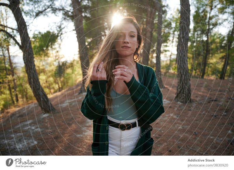 Young woman standing in autumn forest woods nature long hair sunlight season woodland cold female meadow snow sunny fall young environment travel hike adventure