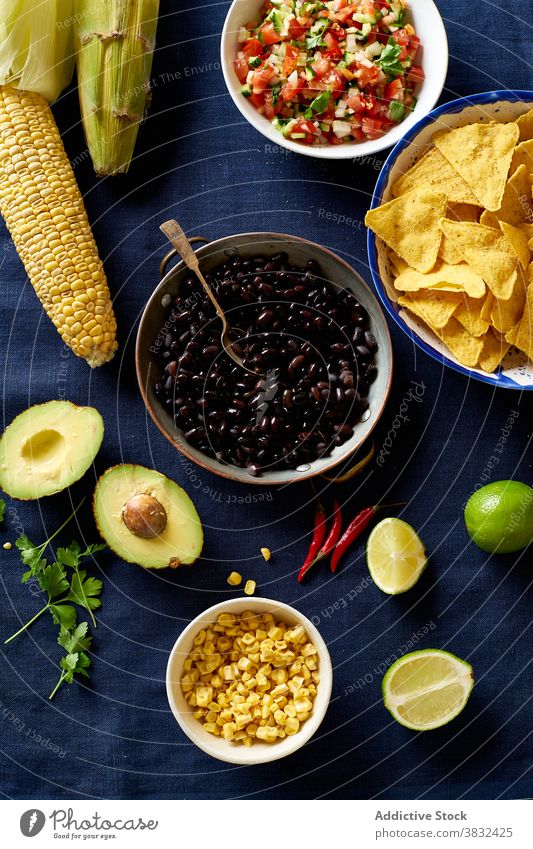 Ingredients for mexican cuisine food chilaquiles dish tortilla ear of corn breakfast black beans nachos cilantro sauce fried meal chips fresh salsa homemade