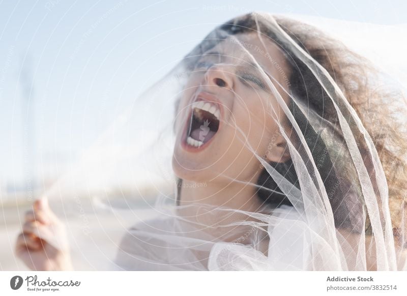 Aggressive annoyed woman in veil shouting bride anger aggressive bodacious angry curly hair scream depress transparent female sunny clear day fearless furious