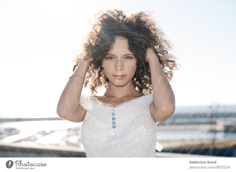 Calm woman in white dress and with curly hair bride cool pensive cityscape sunlight head dreamy calm lace elegant serene female tranquil peaceful trendy natural