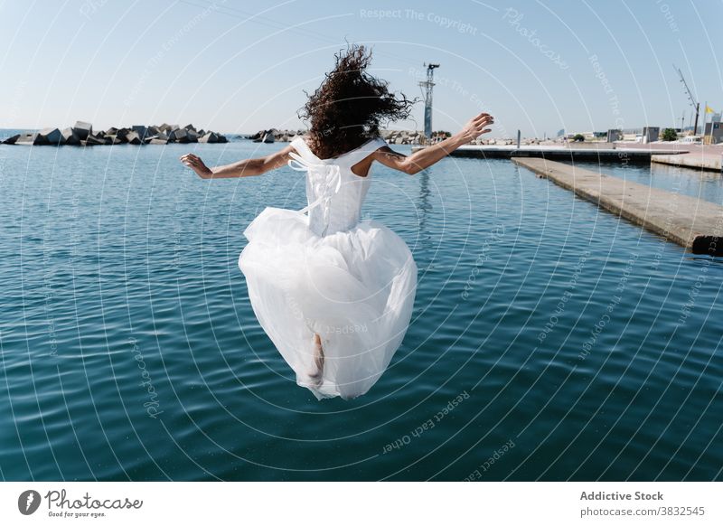 Anonymous woman in bridal dress falling in water white dress seafront lake pier young excited drown fun funky embankment afraid bodacious confused female lady