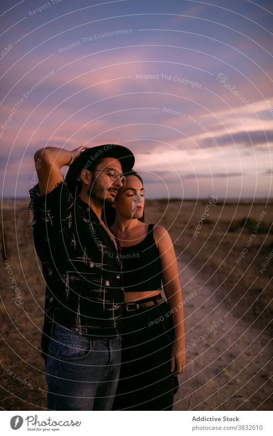 Thoughtful man and woman cuddling in meadow couple sky embrace romantic affection affair in love nature tender summer relationship vibrant colorful vivid sunset