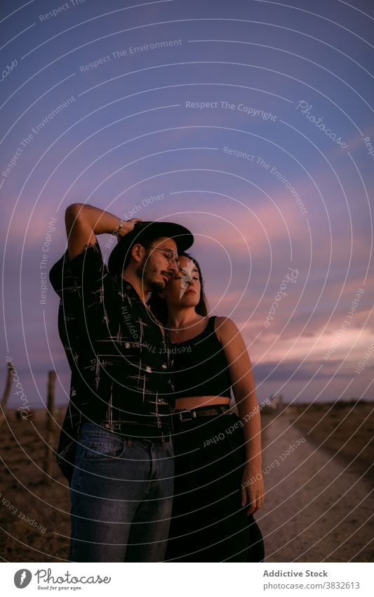 Thoughtful man and woman cuddling in meadow couple sky embrace romantic affection affair in love nature tender summer relationship vibrant colorful vivid sunset