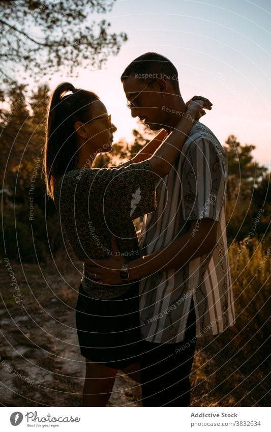 Loving couple hugging in nature at sunset love gentle evening style together relationship sundown sky romantic boyfriend affection casual embrace relax tender