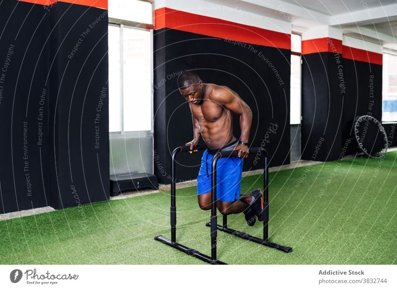 Muscular black man doing triceps exercises on bars gym sportsman parallel athlete workout training functional male ethnic african american power strong muscular