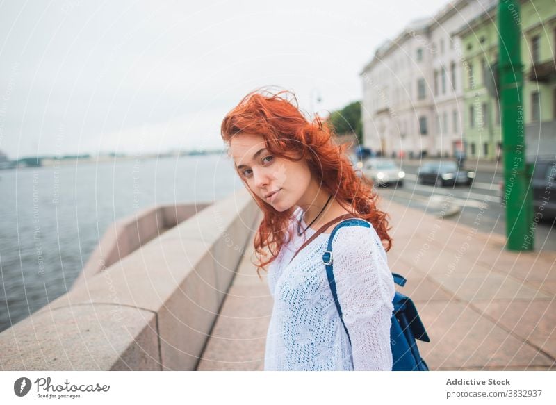 Woman enjoying fresh wind near river in city woman urban freedom traveler bridge sightseeing red hair female redhead tourist saint petersburg russia relax rest