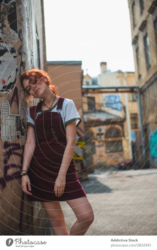 Hipster woman standing near old building with graffiti in city urban hipster millennial shabby aged street district saint petersburg russia russian federation