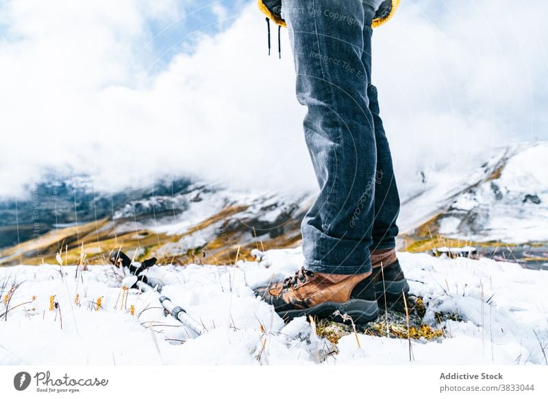 Crop traveler with trekking poles in mountains in winter hiker snow mountaineer slope sunny wintertime pyrenees mountains andorra nature cold vacation trip