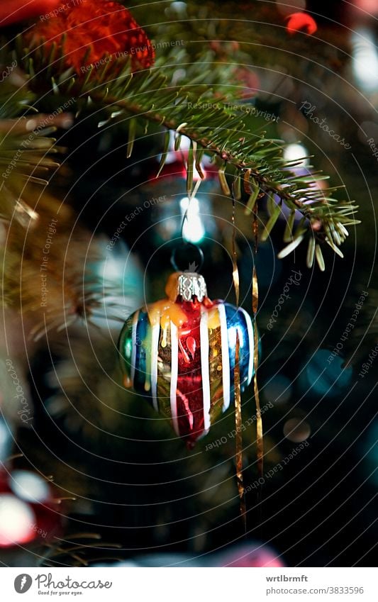 A detail of a classic German Christmas tree with real candles and lots of tinsel and a heart-shaped Christmas decoration. Ornament Decoration Glitter