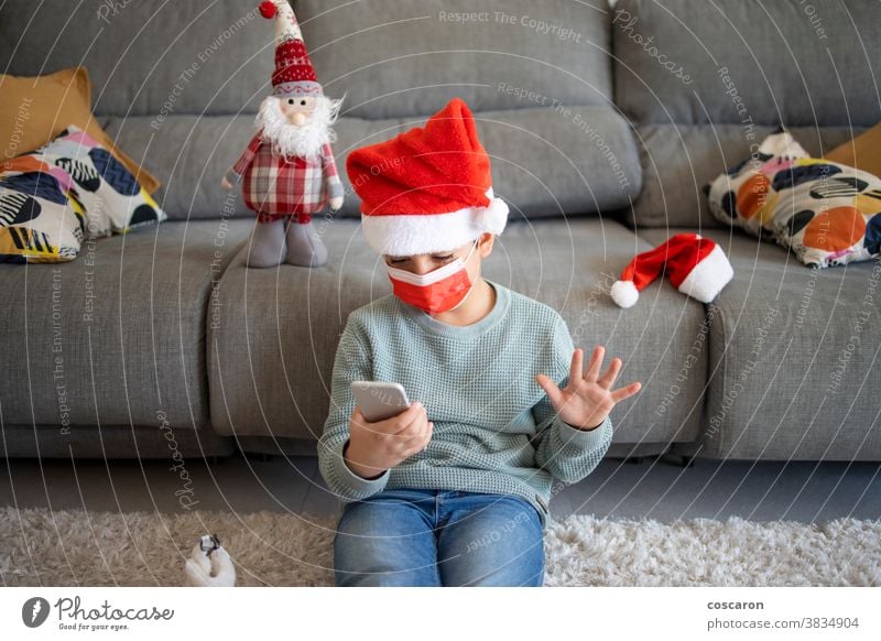 Little kid making a video call on Christmas alone celebration chat child childhood christmas computer concept corona coronavirus covid covid19 device distance