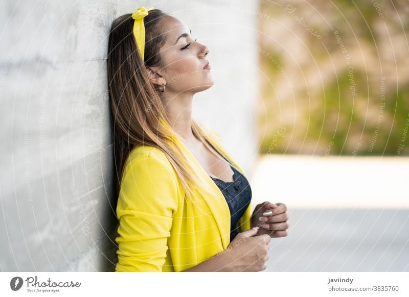 Young woman wearing a yellow jacket and headband girl female person hairstyle straight young beautiful city outdoors lifestyle adult urban happy street modern