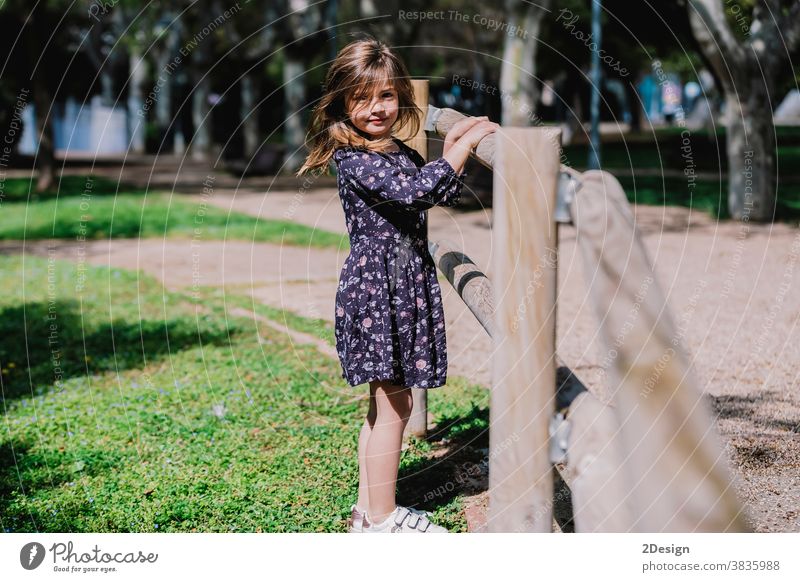 Portrait of a pretty smiling little child girl standing in park outdoors. young adorable childhood cheerful person toddler cute happy boy beautiful portrait