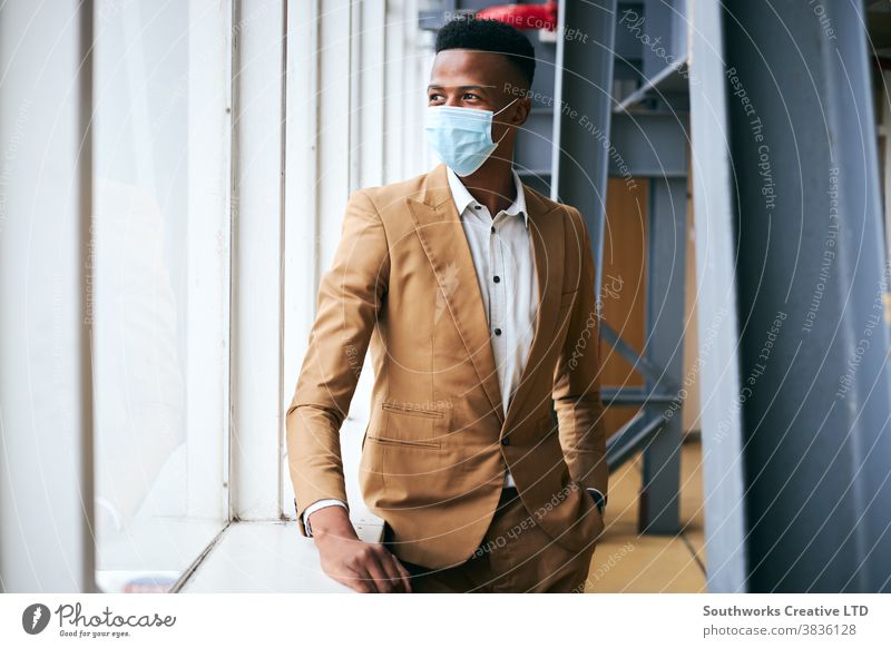 Portrait Of Young Businessman Wearing Mask Standing In Modern Office During Health Pandemic business businessman face mask face covering wearing ppe working