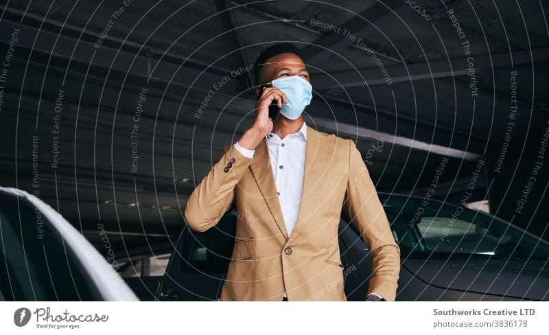 Businessman Wearing Mask Using Mobile Phone In Airport Car Park During Health Pandemic business businessman face mask face covering wearing ppe car park parking