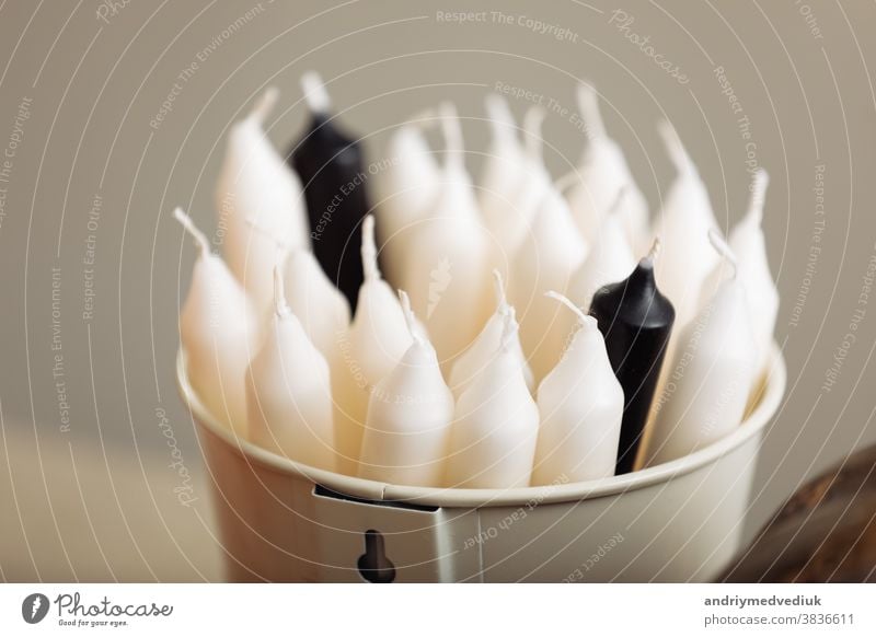 White candle on table, home interior decorations. bucket with candles. selective focus. white nobody background room cozy closeup design romantic wax wick