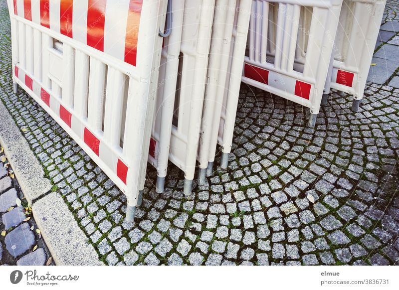 Several red-white barrier beacons are leaning against each other at the roadside Shut-off technology Folding beacons Guide beacon Lane divider Safety