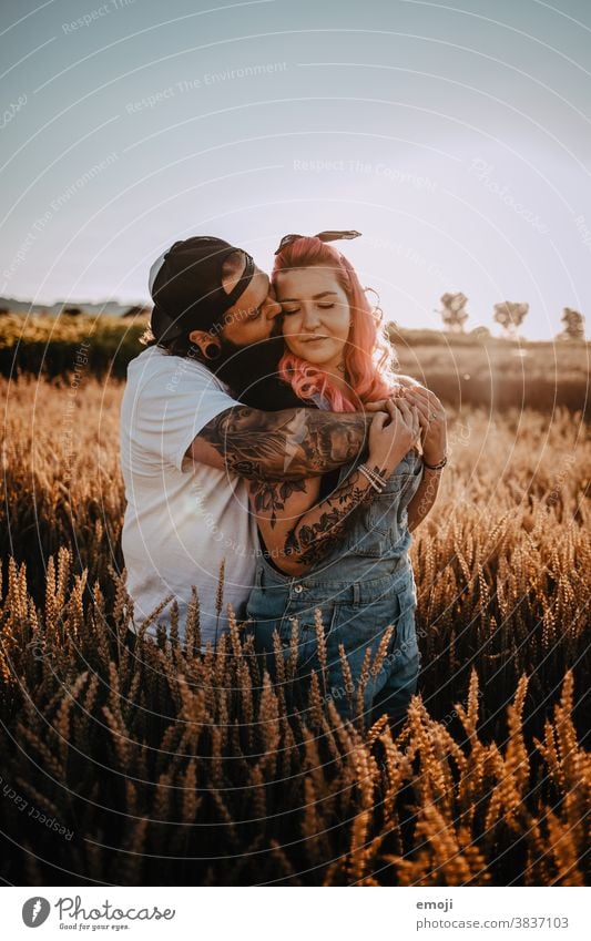 Couple with tattoos and pink hair cuddling in a cornfield at sunset Woman Man Hipster Hip & trendy Cuddling heartfelt Tattoo Cornfield Field out Love In love