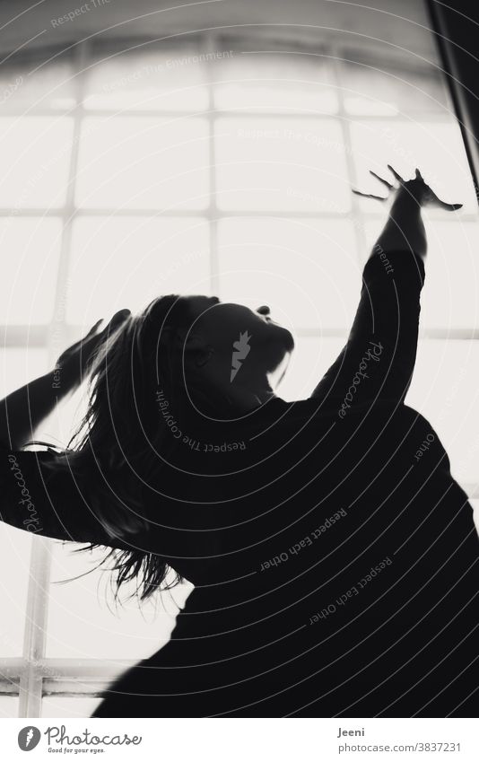 Young woman stands at the window against the light and stretches her arms up Woman Arm Tall hands Back-light Window Feminine Light Sun Silhouette Sunlight