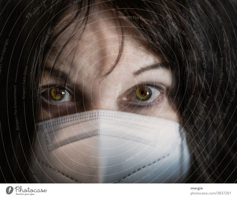 The face of a young woman with mask, mouth guard Front view Mistrust Gaze Head dark colours Dark-haired Girl eyes portrait Human being Feminine