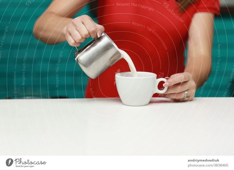 Barista prepares cappuccino in his coffee shop. close-up barista mug work cafe people man hot froth cup milk beverage pour make drink espresso hand preparation