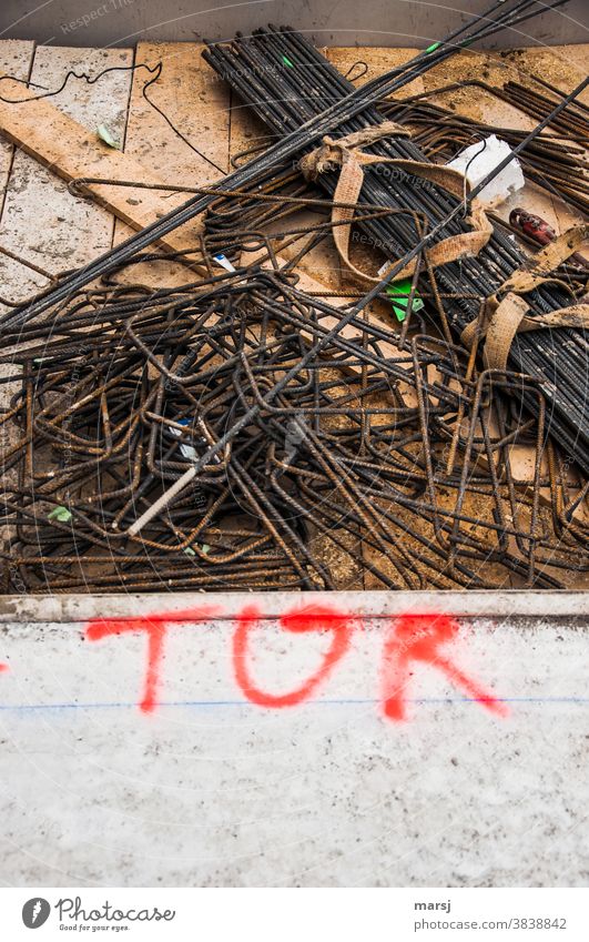 Gate in red letters with reinforcing bars in the background writing Construction site red writing Clue Text Typography Latin script Signs and labeling Word