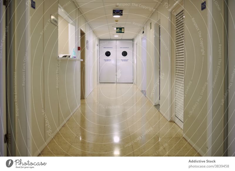 Empty corridor with shiny floor in hospital empty light tile door reflection modern clinic solitude illuminate lamp contemporary passage bright natural ceramic