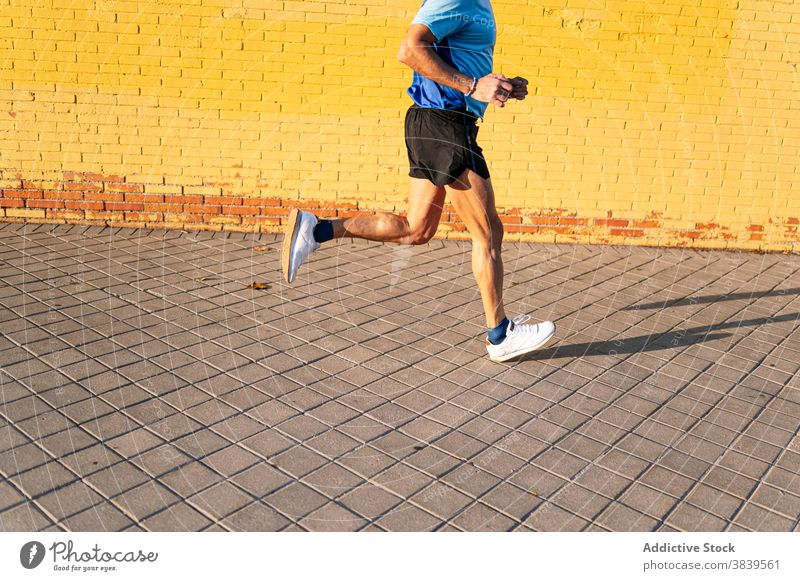 Unrecognizable senior retired man running through the city on yellow background 60 58 rest rythm health care fitness high-blood-pressure training cardiac old