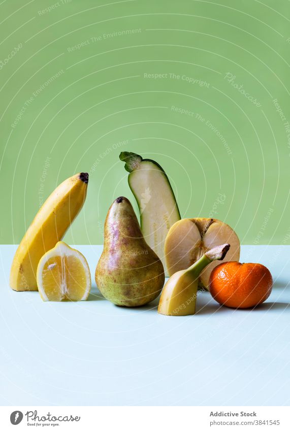 Cut fruits on table in studio cut half abnormal different concept unique healthy fresh various composition arrangement vitamin banana pear tangerine organic