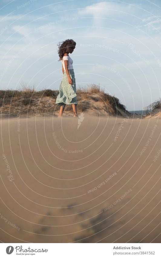 Carefree woman enjoying freedom at sunset grace gentle carefree nature wind tranquil summer ethnic female outfit hill evening flying hair idyllic harmony