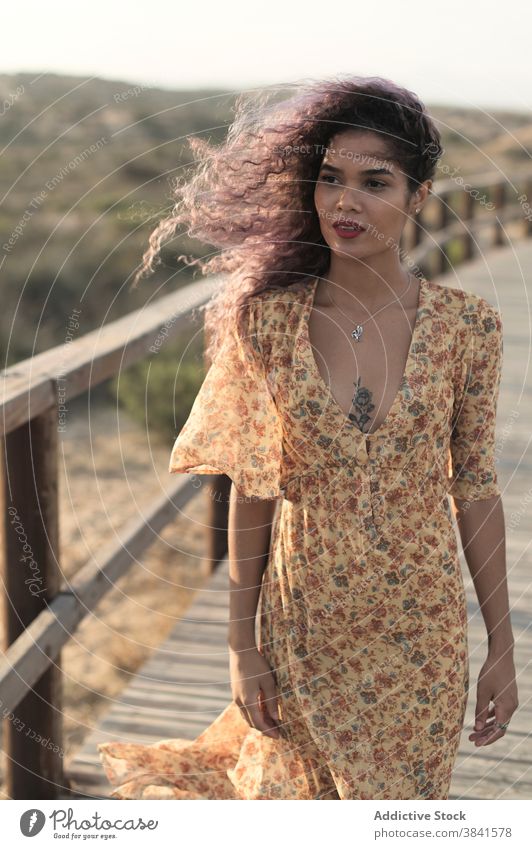 Tender woman on wooden promenade at sunset gentle carefree summer ethnic dress grace freedom slim charming female delicate light nature calm walkway tranquil