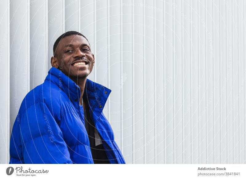 Black stylish man in warm jacket on street style warm clothes cheerful handsome outerwear city confident male ethnic black african american vivid blue color