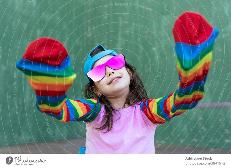 Cheerful girl with rainbow socks on street stripe colorful play child having fun creative outfit hipster playful joy bright trendy style kid smile cool carefree