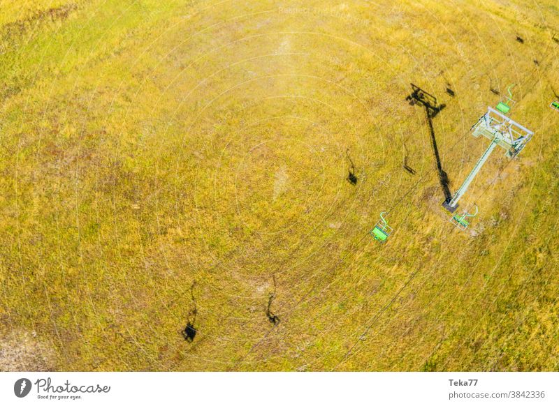 a ski lift in summer from above skilift skilift from above skilift in the summer shadow sun meadow old empty skiing ski resort ski resort in the summer