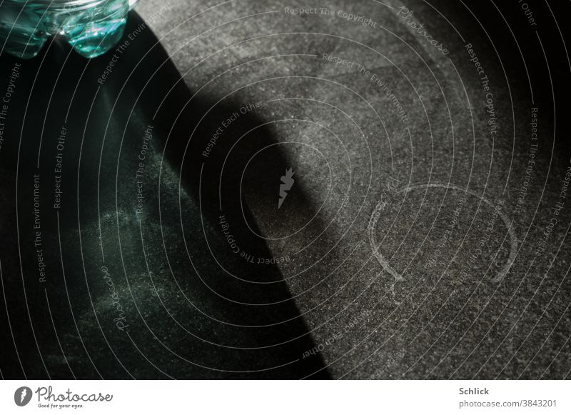 Detail of the bottom of a green PET bottle and ring-shaped water spot on a dark stone plate against the light pet bottle Ring Water mark Stone Dark Black