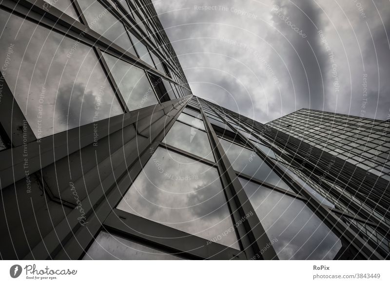 Facade of a modern high-rise building with thunderclouds. High-rise Office Office complex reflection Economy real estate technique Architecture Moody Sky