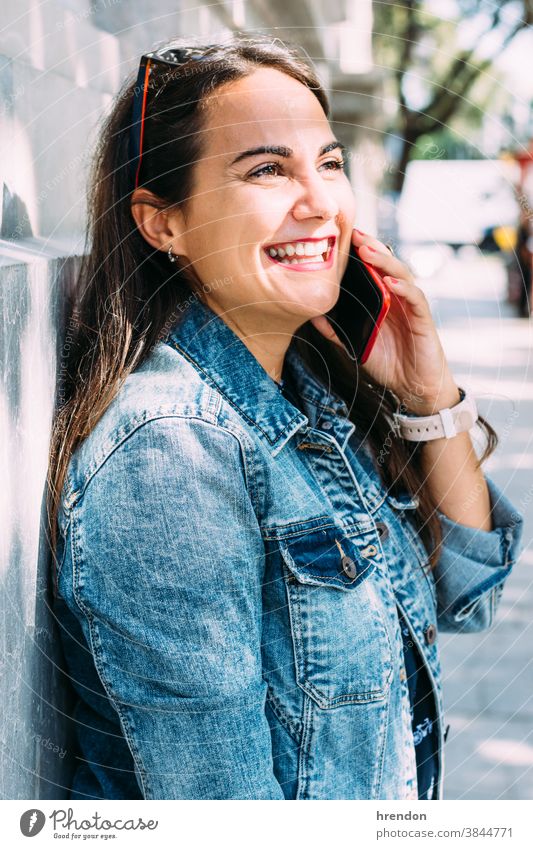 happy woman talks on the phone while walking down the street person communication female smiling talking modern young lifestyle technology urban mobile phone