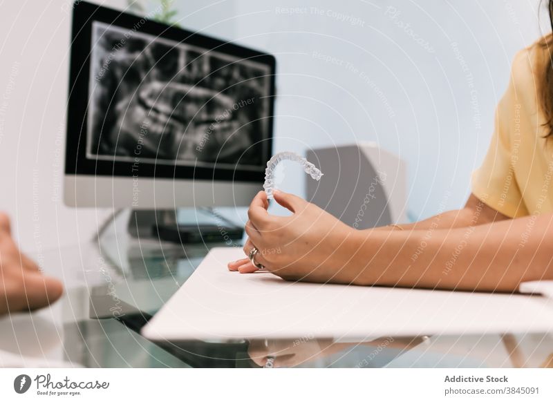 Dentist with invisible braces on his hands and an X-ray in the background tooth orthodontic dentist care mouth beauty dental dentistry transparent patient smile