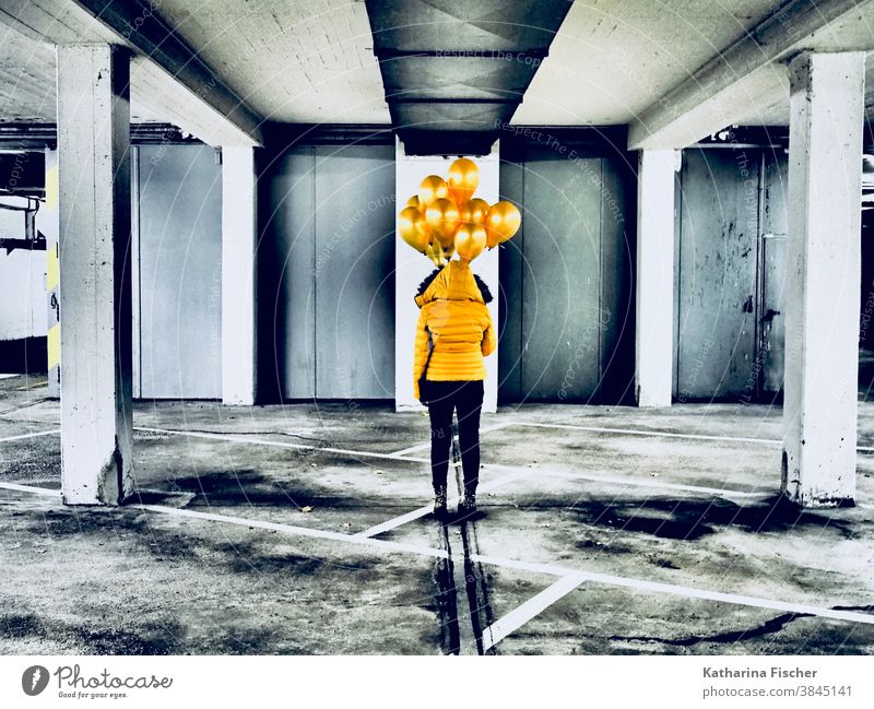 Art, Gold Balloons Yellow balloons Colour photo Underground garage Gray White Black yellow jacket black pants Line Parking garage Stand creatively Creation