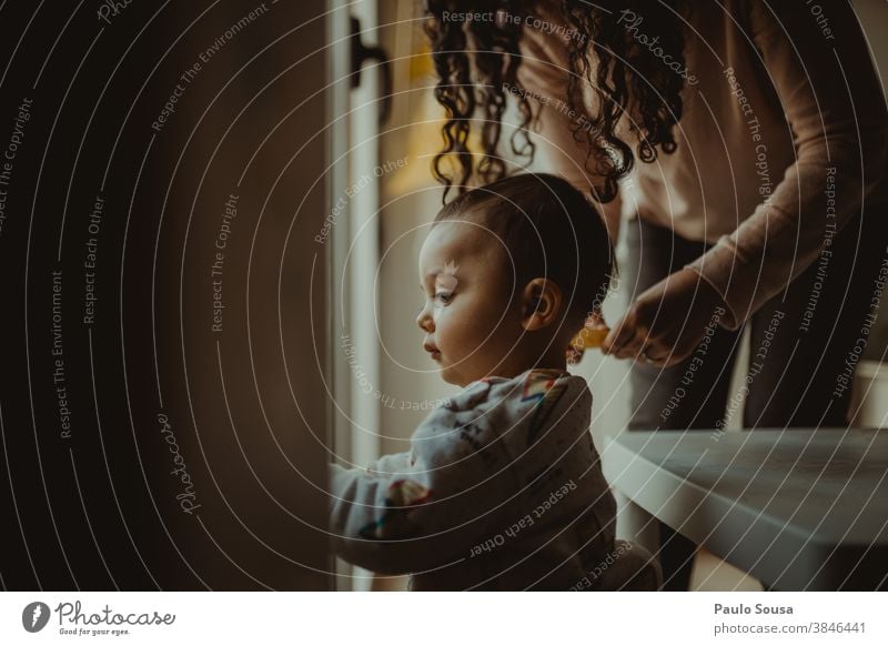 Mother with child at window 0-09 years 30-39 years Learn Learn and Know affectionate at home authentic caring casual caucasian color curiosity curly hair day