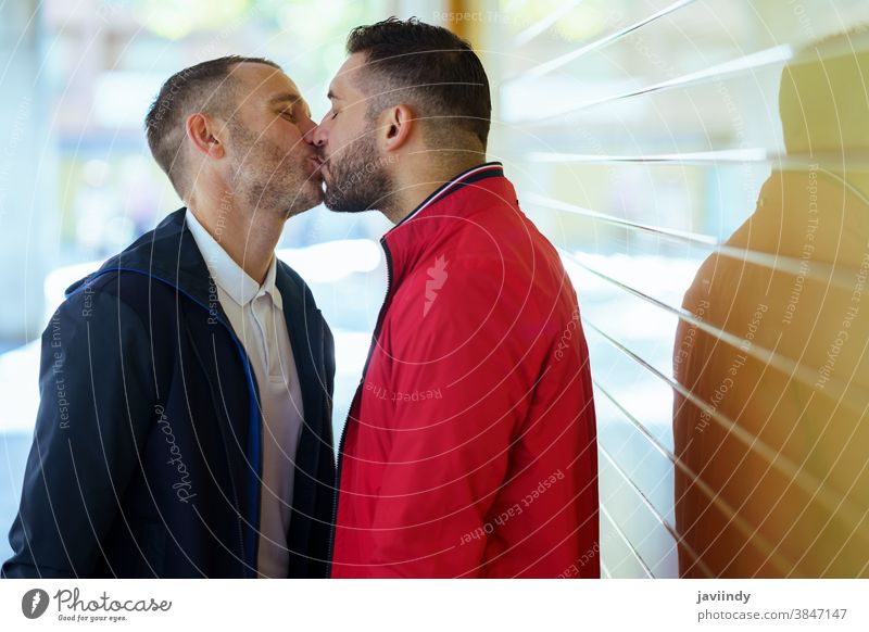 Gay couple in a romantic moment kissing on the street. gay male love homosexual lgbt lgbtq relationship lovers boyfriend people adult outdoor happy outside